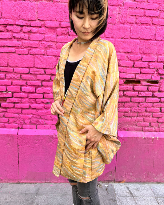 Vintage silk haori jacket with soft watercolor pattern worn by model against bright pink wall, showing relaxed fit and flowing silhouette